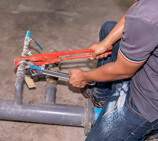 Licensed plumber repairing a copper pipe leak in a North Carolina basement